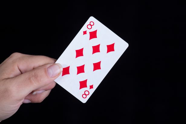 0_Hand-holds-an-eight-of-diamonds-card.jpg