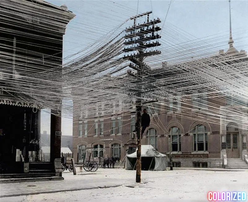 A lineman working on telephone lines at an intersection in Pratt, Kansas in 1911..webp