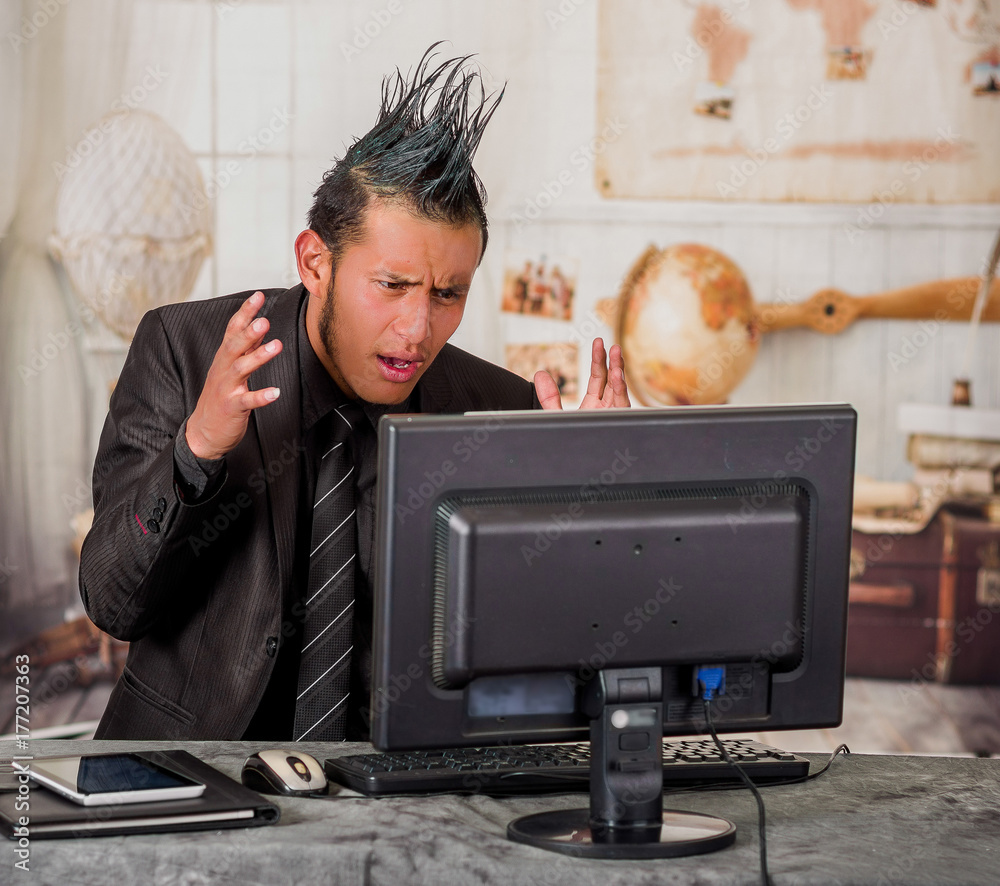 Close up of stressful office punk worker wearing a suit with a crest,  working in a computer, in a blurred background Stock Photo | Adobe Stock