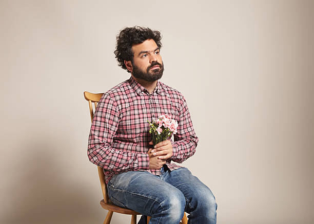 a-man-sitting-with-a-bunch-of-pink-carnations.jpg