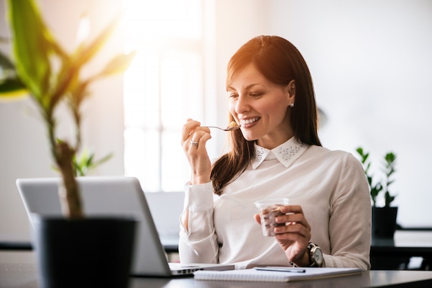 young-smiling-woman-eating-ice-cream-office_109710-5085.jpg